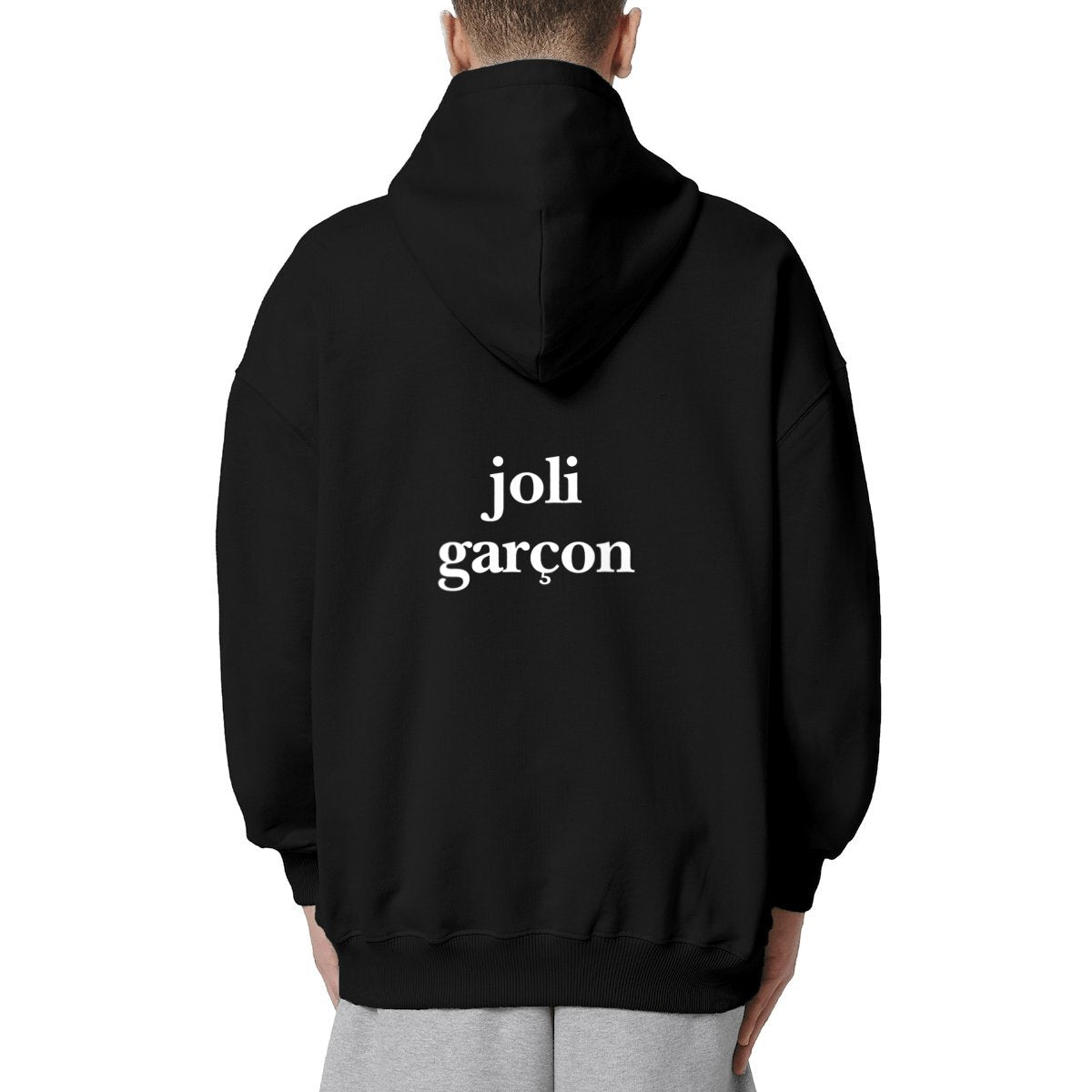 joli garçon hoodie over. garçon garçon essentiel black oversized hoodie. Encapsulate effortless Parisian cool with this hoodie, its subtle 'joli garçon ON THE BACK' emblem whispering understated sophistication. Crafted for comfort, styled for streets of Paris.